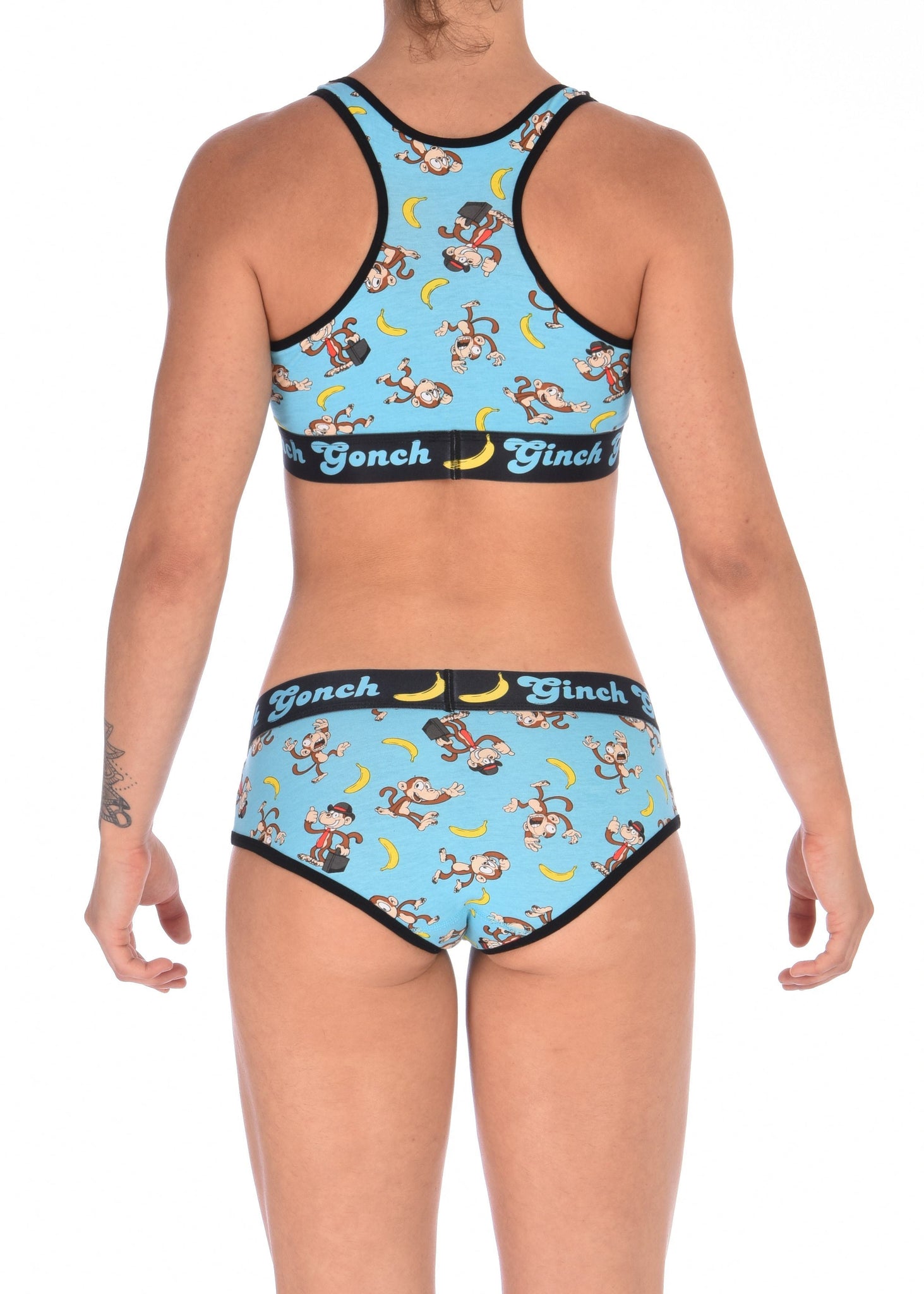 Ginch Gonch Monkey Business Women's Underwear boy cut brief with y front, with blue background, monkeys, and bananas. Black trim and printed waistband with Ginch Gonch and bananas. Back. Matching Sports Bra.